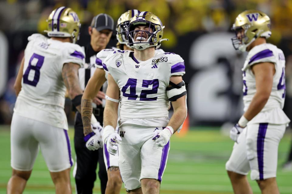 Washington Huskies linebacker Carson Bruener (42) reacts after a play against the Michigan Wolverines during the third quarter in the 2024 College Football Playoff national championship game at NRG Stadium Jan. 8, 2024.