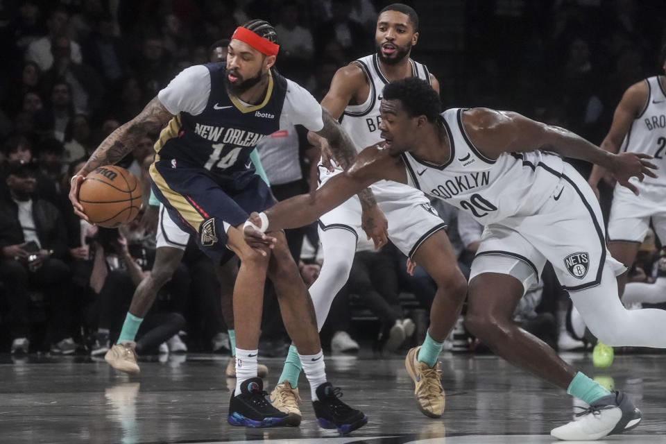 Brooklyn Nets' Day'Ron Sharpe, right, swipes at the ball as New Orleans Pelicans' Brandon Ingram control during the first half of an NBA basketball game, Tuesday, March 19, 2024, in New York. (AP Photo/Bebeto Matthews)