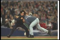 Security officers apprehend a fan who ran onto the field during Game Two of the World Series between the New York Yankees and the Atlanta Braves at Yankee Stadium in New York City, New York. The Braves won the game, 4-0.