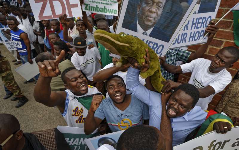 辛巴威民眾高舉鱷魚娃娃，諷刺長年鎮壓反對人士的「鱷魚」副總統姆納加瓦。（美聯社）