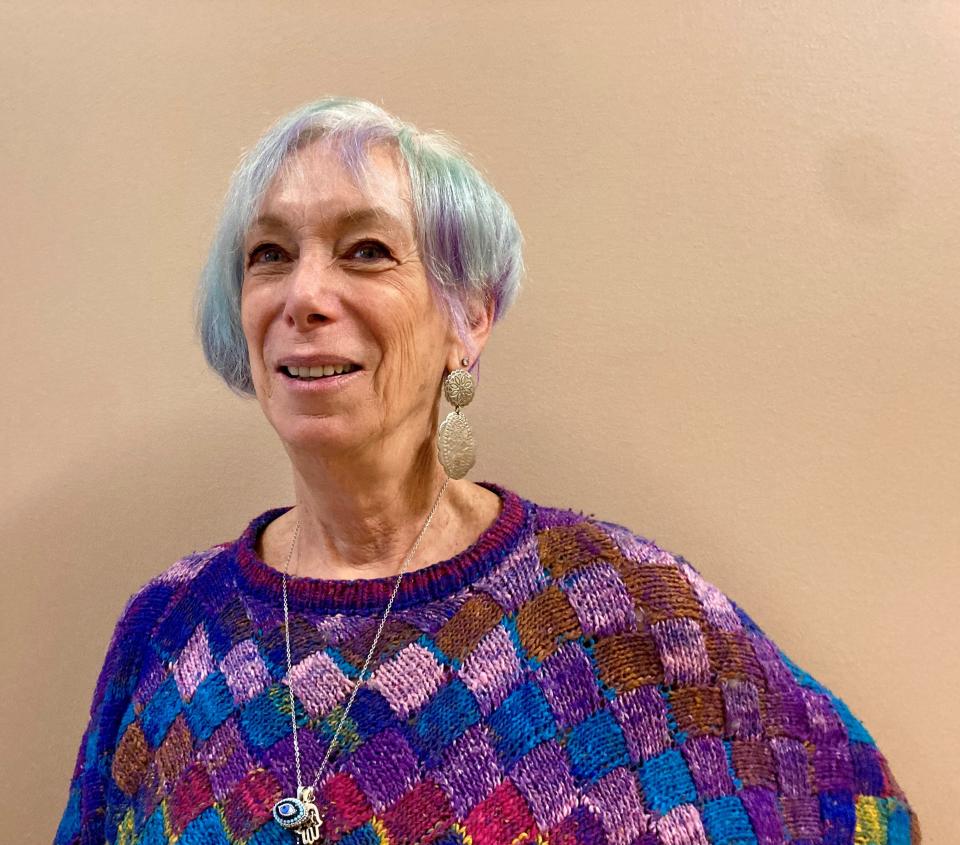 Karen Goldman’s hair is vibrantly colored in purple and a pale green that matches her eyes. She said that she started dyeing smaller sections a few decades ago, but over the years that expanded to her entire head. She says that she changes the color regularly.