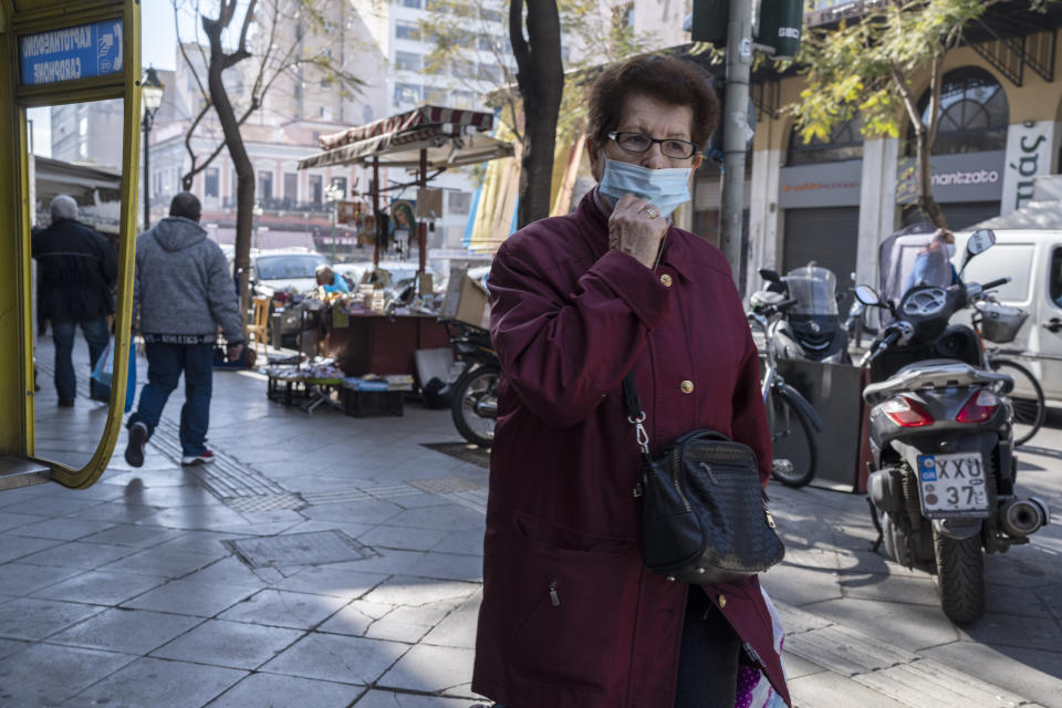 An elderly woman wearing a face mask to curb the spread of coronavirus, walks in central Athens on Monday, Jan. 17, 2022. Greece has imposed a vaccination mandate for people over age 60, as coverage remains below the European Union average and while a recent spike in infections has sustained pressure on hospitals. (AP Photo/Petros Giannakouris)