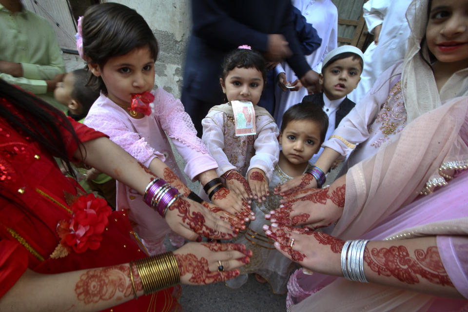 Niñas musulmanas muestran sus manos pintadas con henna con diseños tradicionales para celebrar el Eid al-Fitr, que marca el final del Ramadán, en Peshawar, Pakistán, el miércoles 10 de abril de 2024. (AP Foto/Muhammad Sajjad)