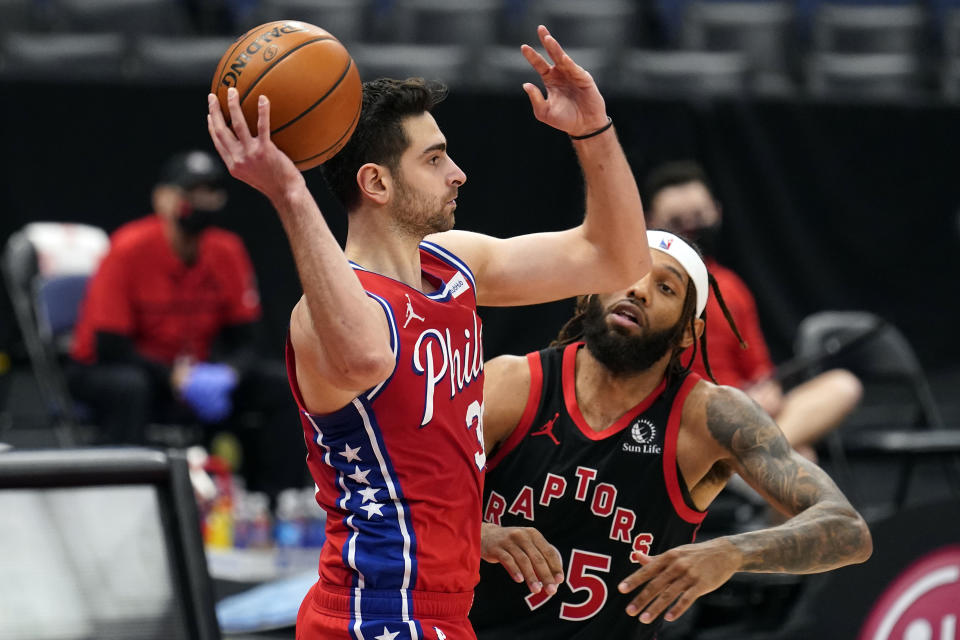 Philadelphia 76ers guard Furkan Korkmaz (30) looks to pass in front of Toronto Raptors forward DeAndre' Bembry (95) during the second half of an NBA basketball game Tuesday, Feb. 23, 2021, in Tampa, Fla. (AP Photo/Chris O'Meara)