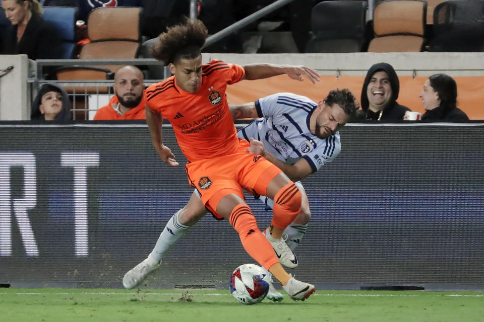 Houston Dynamo midfielder Adalberto Carrasquilla, left, moves the ball in front of Sporting Kansas City defender Tim Leibold, right, during the first half of an MLS playoff soccer match, Sunday, Nov. 26, 2023, in Houston. (AP Photo/Michael Wyke)
