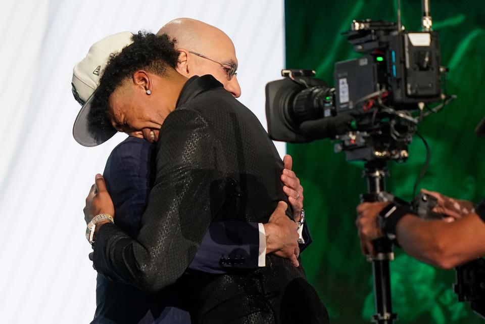 MarJon Beauchamp hugs NBA Commissioner Adam Silver after being selected 24th overall by the Milwaukee Bucks in the NBA basketball draft, Thursday, June 23, 2022, in New York. (AP Photo/John Minchillo)