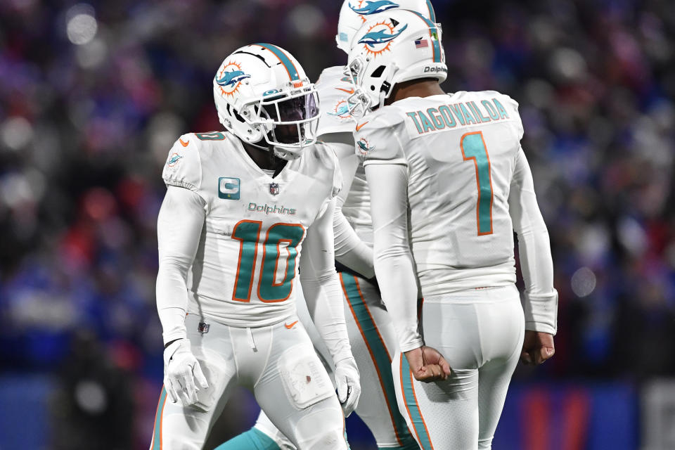 Miami Dolphins wide receiver Tyreek Hill (10) celebrates a touchdown with quarterback Tua Tagovailoa during the second half of an NFL football gameagainst the Buffalo Bills in Orchard Park, N.Y., Saturday, Dec. 17, 2022. (AP Photo/Adrian Kraus)