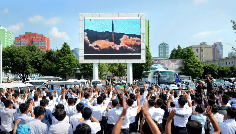 <p>People watch a huge screen showing the test launch of intercontinental ballistic missile Hwasong-14 in this undated photo released by North Korea’s Korean Central News Agency (KCNA), July 5, 2017. (Photo: KCNA/via Reuters) </p>