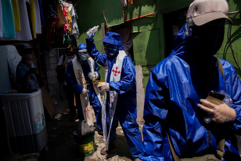 The Wider Image: Hazmat suits and holy water: two priests bring faith to Philippines lockdown