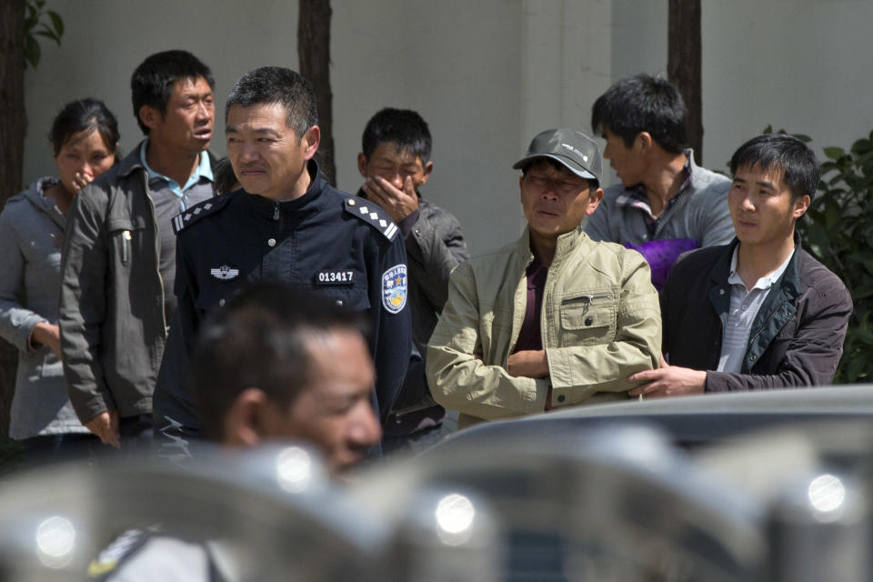 A man is supported by a relative as they leave a funeral home where bodies of victims killed in Saturday night's attack are kept in Kunming, in southwestern China's Yunnan province, Monday, March 3, 2014. Twenty-nine slash victims and four attackers were killed and 143 people wounded in the attack which officials said was a terrorist assault by ethnic separatists from the far west. (AP Photo/Alexander F. Yuan)