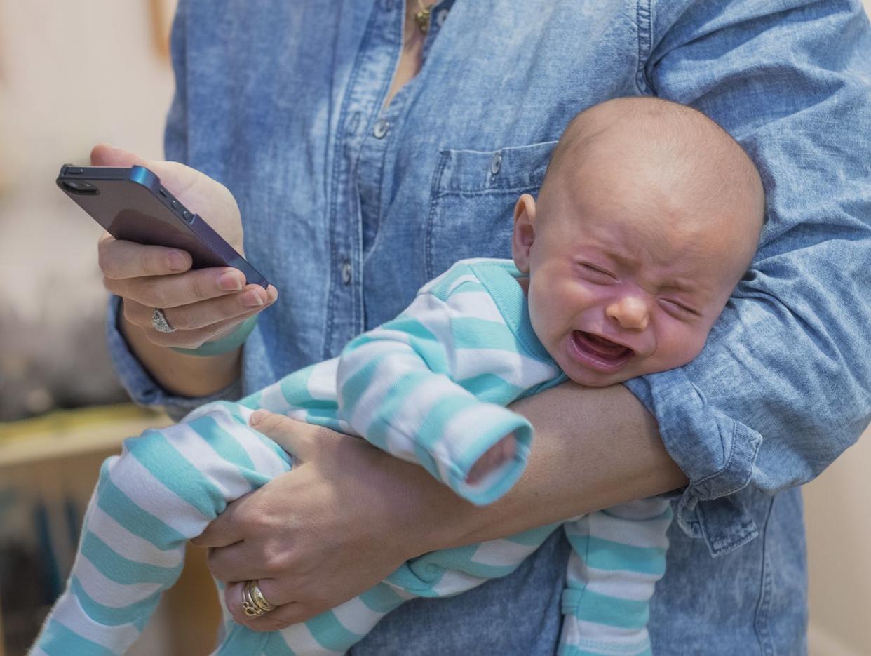 <span class="caption">Babies don't come with instruction manuals... mobile health apps can help new parents.</span> <span class="attribution"><a class="link " href="https://www.gettyimages.com/detail/photo/new-jersey-jersey-city-woman-texting-and-holding-royalty-free-image/525445885" rel="nofollow noopener" target="_blank" data-ylk="slk:Tetra Images via Getty Images;elm:context_link;itc:0;sec:content-canvas">Tetra Images via Getty Images</a></span>