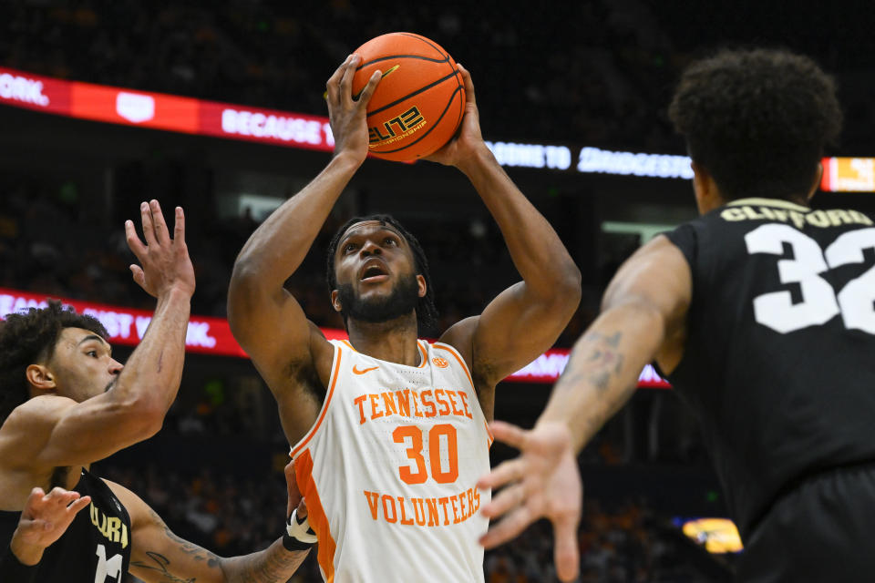 Tennessee guard Josiah-Jordan James (30) shoots as Colorado guard J'Vonne Hadley, left, and Colorado guard Nique Clifford, right, defend during the first half of an NCAA college basketball game, Sunday, Nov. 13, 2022, in Nashville, Tenn. (AP Photo/John Amis)