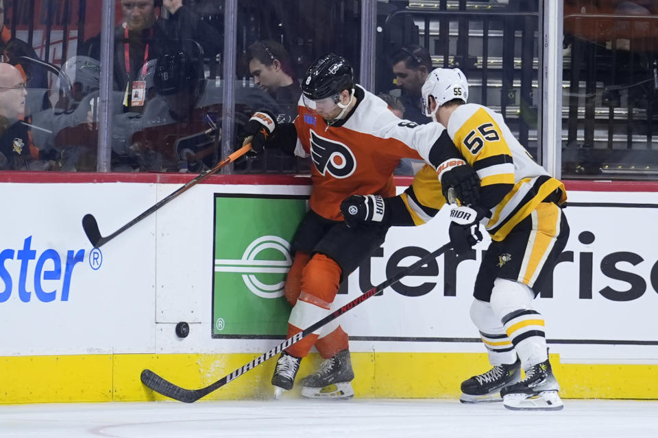Philadelphia Flyers' Cam York, left, tries to keep the puck away from Pittsburgh Penguins' Noel Acciari during the second period of an NHL hockey game, Monday, Jan. 8, 2024, in Philadelphia. (AP Photo/Matt Slocum)
