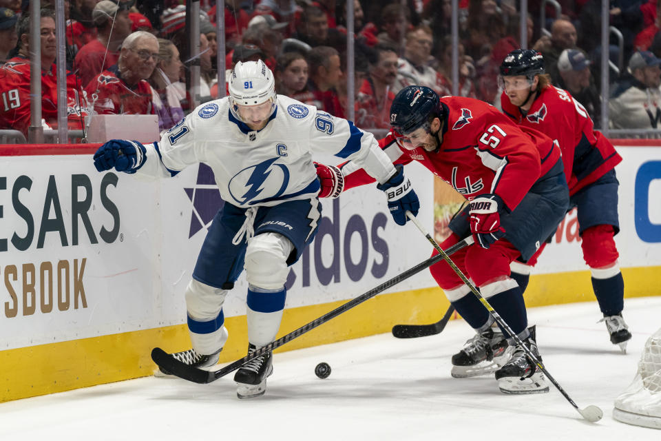 Tampa Bay Lightning center Steven Stamkos (91) and Washington Capitals defenseman Trevor van Riemsdyk (57) vie for control of the puck during the second period of an NHL hockey game, Saturday, Dec. 23, 2023, in Washington. (AP Photo/Stephanie Scarbrough)