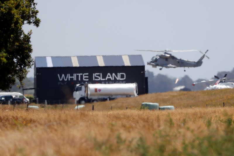 A military helicopter flies at the airport during the rescue mission following the White Island volcano eruptions in Whakatane