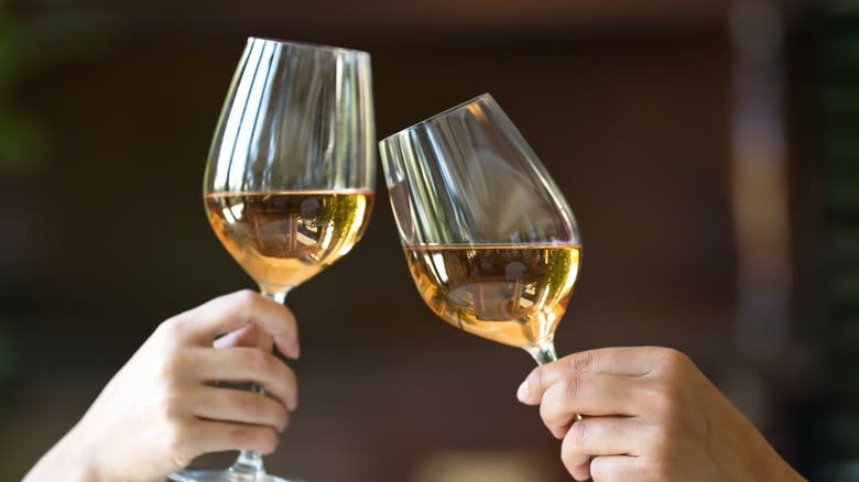 two hands holding wine glasses