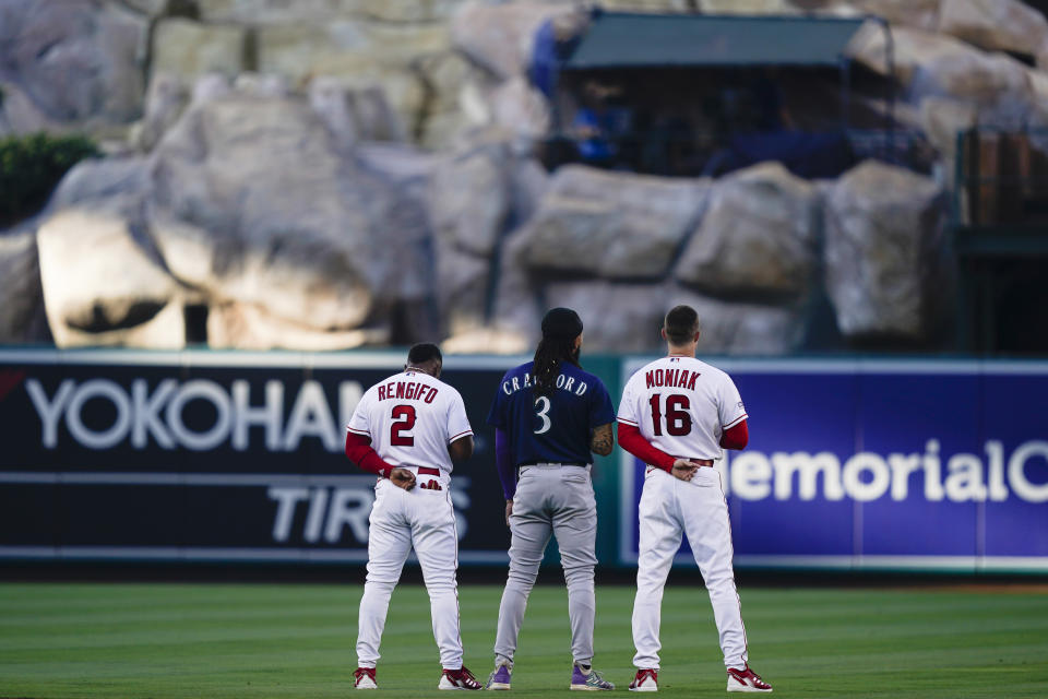 Los Angeles Angels second baseman Luis Rengifo (2), Seattle Mariners shortstop J.P. Crawford (3) and Angels center fielder Mickey Moniak (16) stand for the national anthem before a baseball game Thursday, Aug. 3, 2023, in Anaheim, Calif. (AP Photo/Ryan Sun)