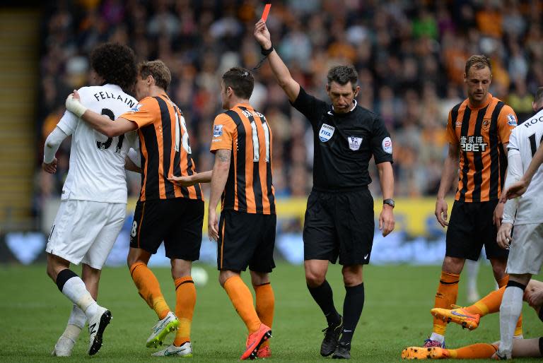 Referee Lee Probert (4L) shows a red card to Manchester United's Belgian midfielder Marouane Fellaini (L) who is shepherded away by Hull City's Croatian striker Nikica Jelavic (2L) after a foul in Kingston upon Hull, England on May 24, 2015