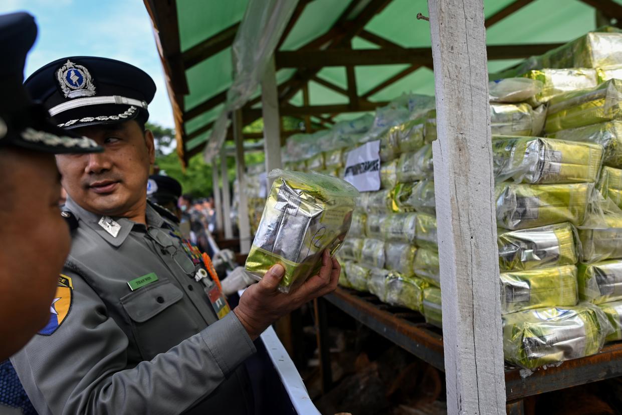 A Myanmar police official holds a pack of drugs before burning during a destruction ceremony to mark the UN's "International Day against Drug Abuse and Illicit Trafficking" in Yangon on June 26, 2019. (Photo by Ye Aung THU / AFP)        (Photo credit should read YE AUNG THU/AFP/Getty Images)