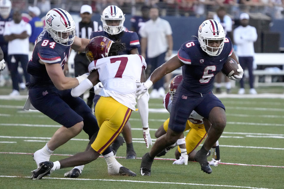 Arizona running back Michael Wiley (6) runs the ball by Southern California defensive back Calen Bullock (7) in the first half during an NCAA college football game, Saturday, Oct. 29, 2022, in Tucson, Ariz. (AP Photo/Rick Scuteri)