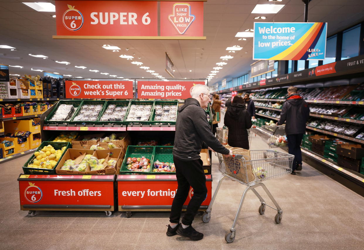 A shopper walks inside an ALDI supermarket near Altrincham, Britain, February 20, 2023. REUTERS/Phil Noble