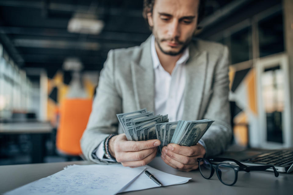 person counting money at a desk