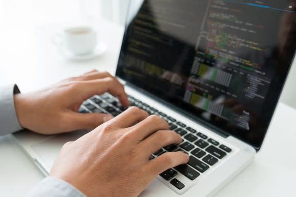 A person writing code on his computer.