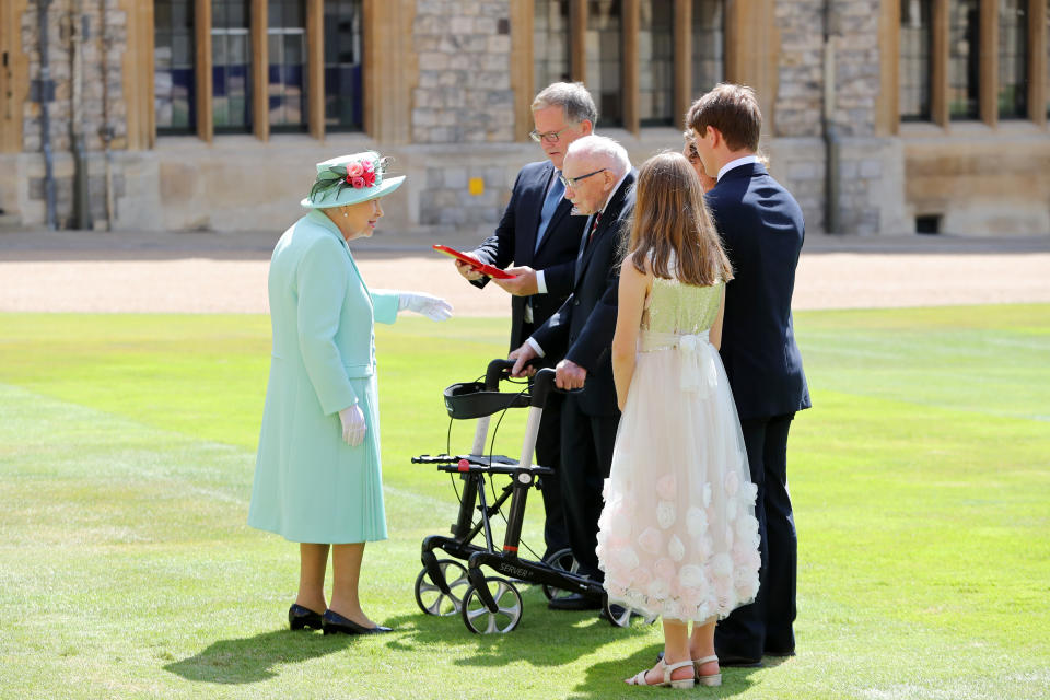 WINDSOR, ENGLAND - JULY 17: Queen Elizabeth II talks Captain Sir Thomas Moore and his family after awarding him with the insignia of Knight Bachelor at Windsor Castle on July 17, 2020 in Windsor, England. British World War II veteran Captain Tom Moore raised over £32 million for the NHS during the coronavirus pandemic.  (Photo by Chris Jackson/Getty Images)