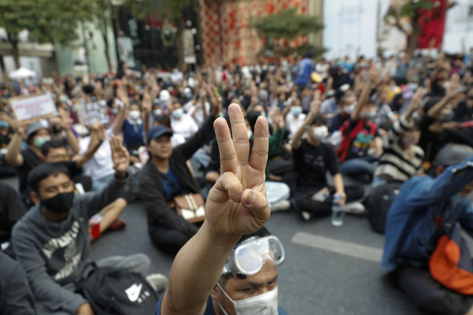 Pro-democracy protesters flash the three-finger protest salute during an anti-government rally at a major intersection in Bangkok, Thailand, Wednesday, Nov. 18, 2020. Police in Thailand's capital braced for possible trouble Wednesday, a day after a protest outside Parliament by pro-democracy demonstrators was marred by violence that left dozens of people injured. (AP Photo/Sakchai Lalit)