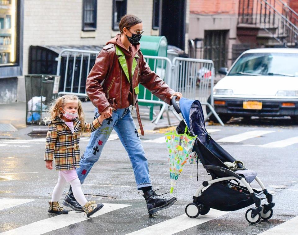 <p>Holding her's and ex-partner Bradley Cooper's daughter's hand, Shayk looked fierce in lace-up boots, medium-wash jeans, and a brown biker jacket with green accents.</p>