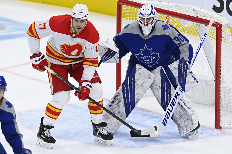 Calgary Flames left wing Milan Lucic (17) and Toronto Maple Leafs goaltender Michael Hutchinson (30) watch the play during first period NHL action in Toronto on Wednesday, Feb. 24, 2021. (Frank Gunn/The Canadian Press via AP)