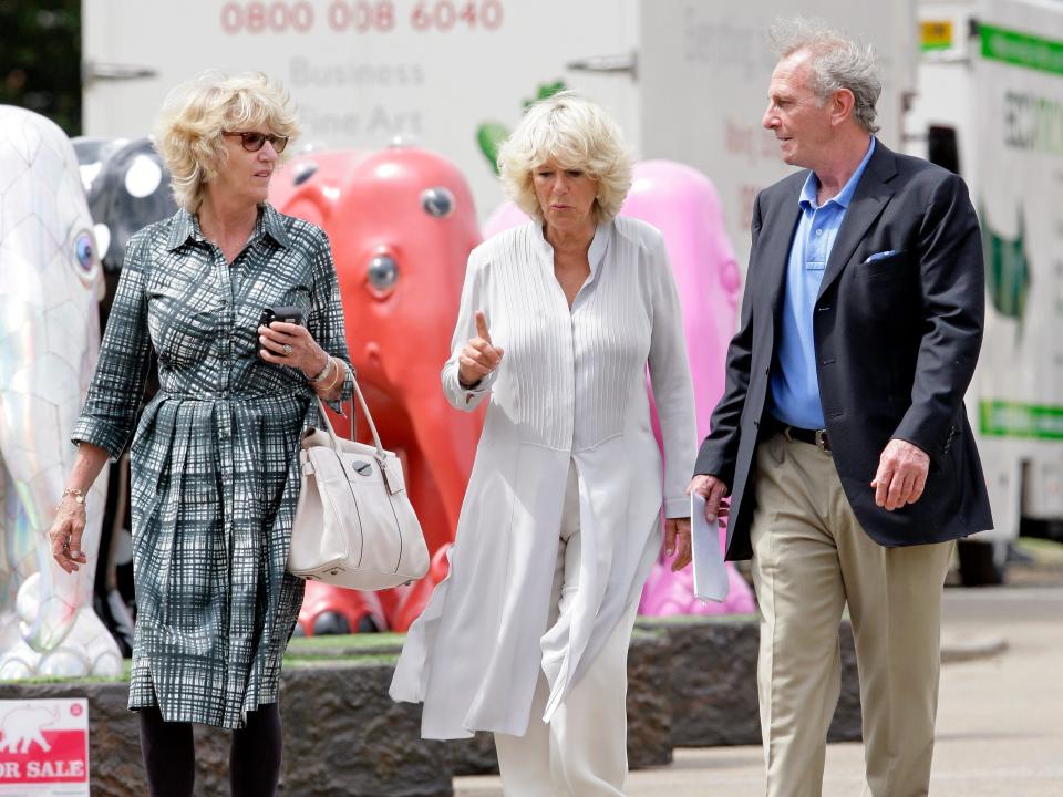 Camilla, Duchess of Cornwall walks between her sister Annabel and brother Mark.