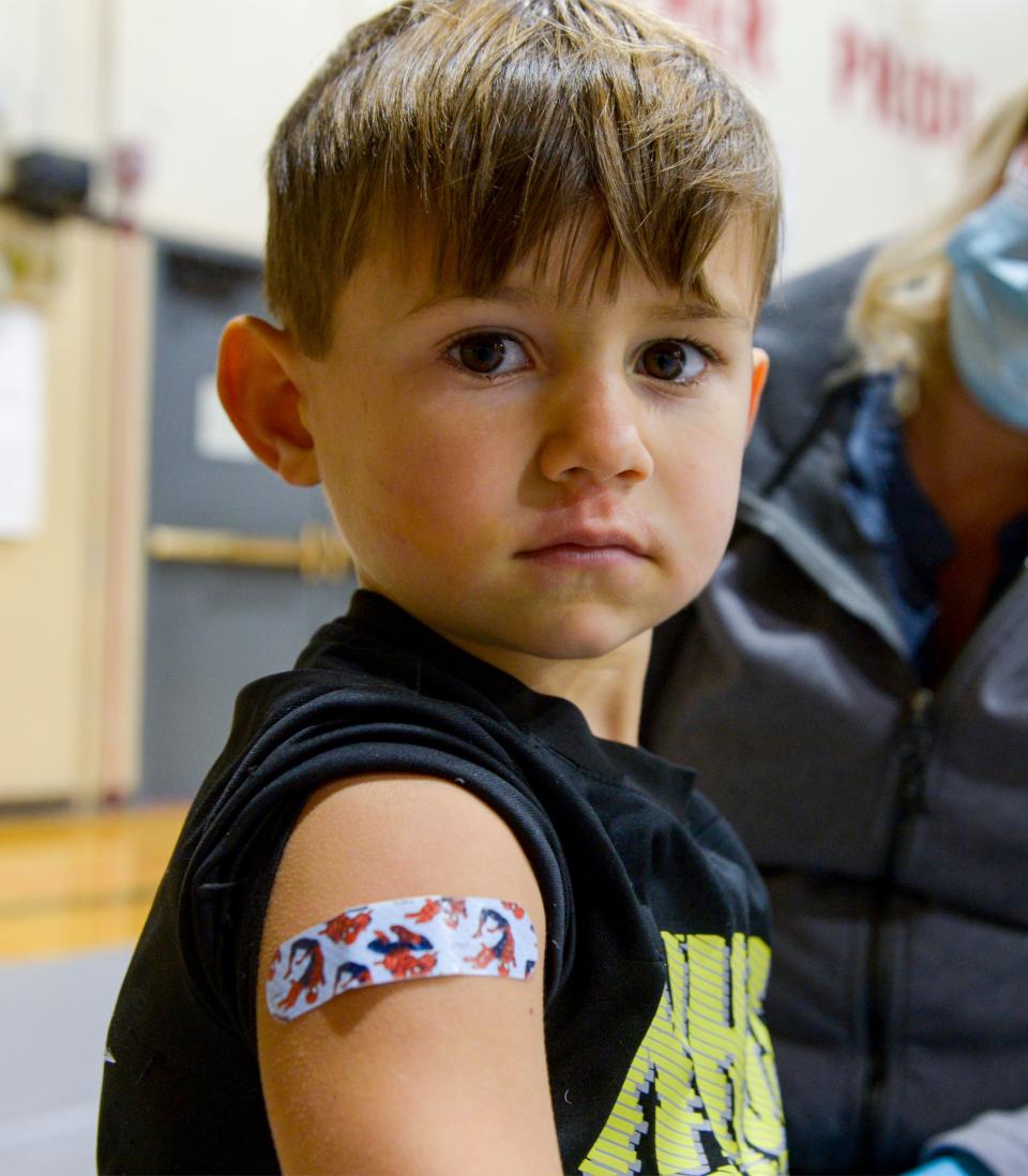 Drew Bryant, age 5, shows off his bandage after getting his flu and COVID vaccines at the Alluvion Health vaccine clinic on Wednesday evening at Paris Gibson Education Center.