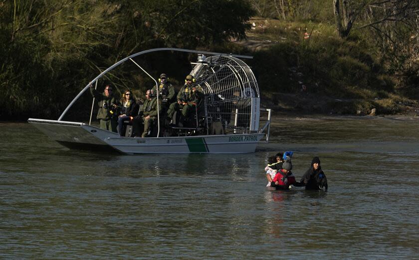 Border patrol agents watch as migrants cross the Rio Grande at the Texas-Mexico border, Wednesday, Jan. 3, 2024, in Eagle Pass, Texas. (AP Photo/Eric Gay)