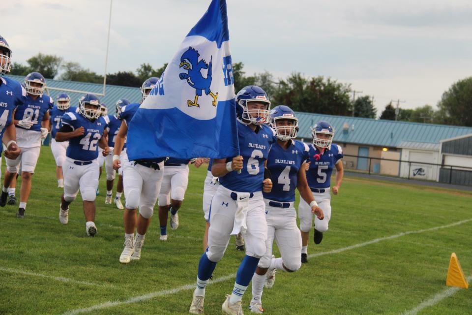 The Perry Bluejays run onto Dewey Field on Aug. 19 during the season opener in Perry. Perry has since forfeited the remaining three games of the varsity season.