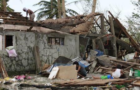 Residents sift through the ruins of their houses after strong winds and heavy rains brought by typhoon Melor battered Barcelona town, Sorsogon province, central Philippines December 15, 2015. REUTERS/Eduardo Guinio