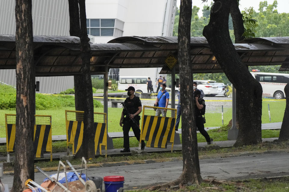 Armed police walk inside the Ateneo de Manila University in Quezon city, Philippines, Sunday, July 24, 2022. At least three people, including a former Philippine town mayor, were killed and another was wounded in a brazen attack on Sunday by a gunman in a university campus in the capital region, officials said. (AP Photo/Aaron Favila)