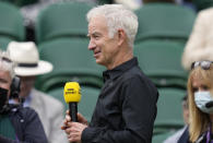 Former Wimbledon champion John McEnroe gives a TV interview ahead of the start of the men's singles final between Serbia's Novak Djokovic and Italy's Matteo Berrettini on day thirteen of the Wimbledon Tennis Championships in London, Sunday, July 11, 2021. (AP Photo/Kirsty Wigglesworth)