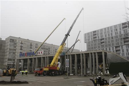 Building cranes remove debris from a collapsed supermarket in capital Riga November 22, 2013. REUTERS/Ints Kalnins