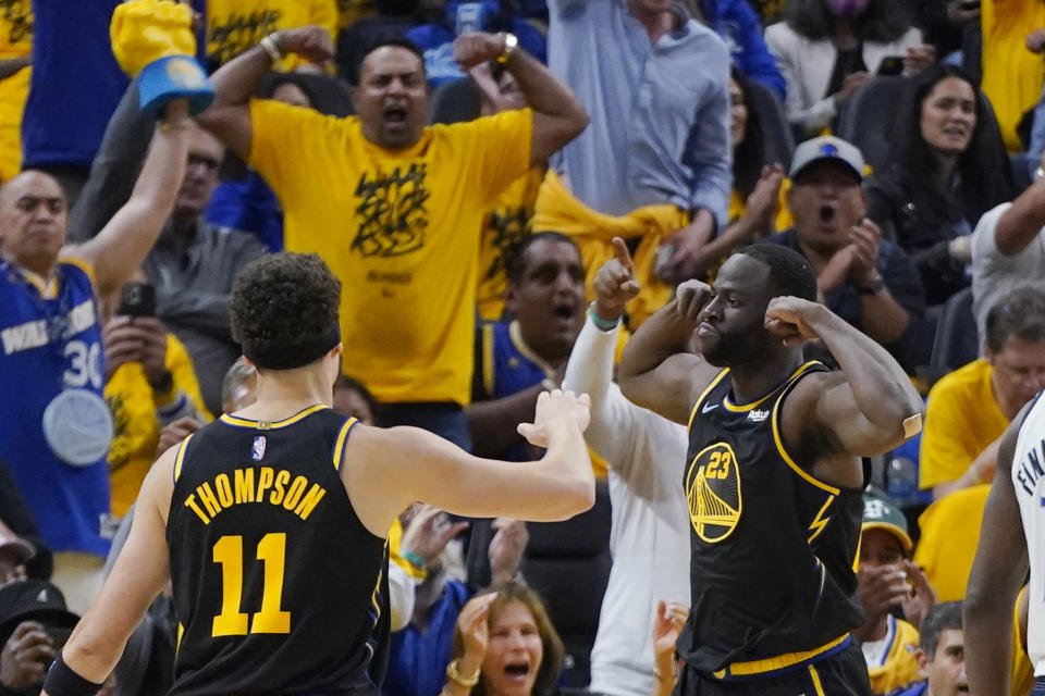 Golden State Warriors forward Draymond Green (23) celebrates next to guard Klay Thompson (11) during the first half in Game 5 of the team's NBA basketball playoffs Western Conference finals against the Dallas Mavericks in San Francisco, Thursday, May 26, 2022. (AP Photo/Jeff Chiu)