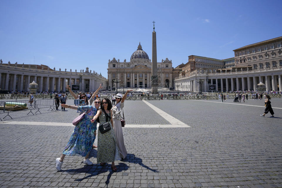 People take selfie photos in front of St. Peter's Basilica at The Vatican in Rome, Thursday, June 8, 2023, the day after Pope Francis underwent surgery to repair a hernia in his abdominal wall, the latest malady to befall the 86-year-old pontiff who had part of his colon removed two years ago. (AP Photo/Alessandra Tarantino)