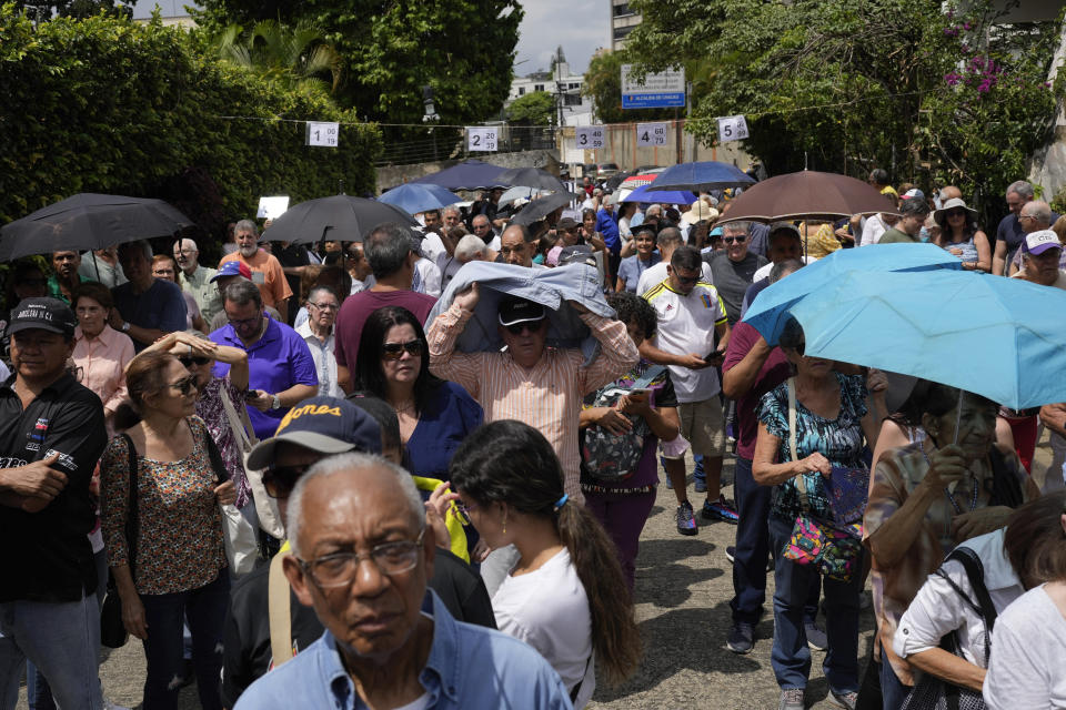 People stand in line to vote at a polling station during the opposition primary election in Caracas, Venezuela, Sunday, Oct. 22, 2023. The opposition will pick one candidate to challenge President Nicolás Maduro in 2024 presidential elections. (AP Photo/Matias Delacroix)