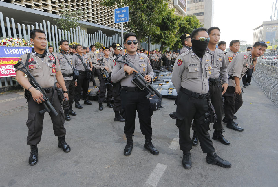 Riot police stand guard outside the General Election Supervisory Board building in anticipation of protests in Jakarta, Indonesia, Tuesday, May 28, 2019. Four top Indonesian officials, including two Cabinet ministers and the national spy chief, were targeted for assassination as part of a plot possibly linked to last week's election riots, police said Tuesday. (AP Photo/Tatan Syuflana)