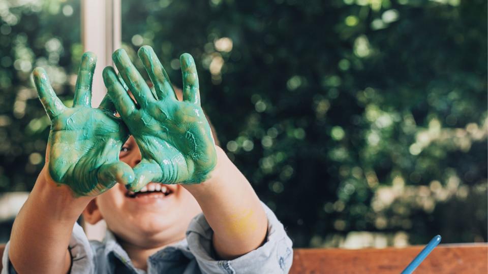 kid with paint on hands