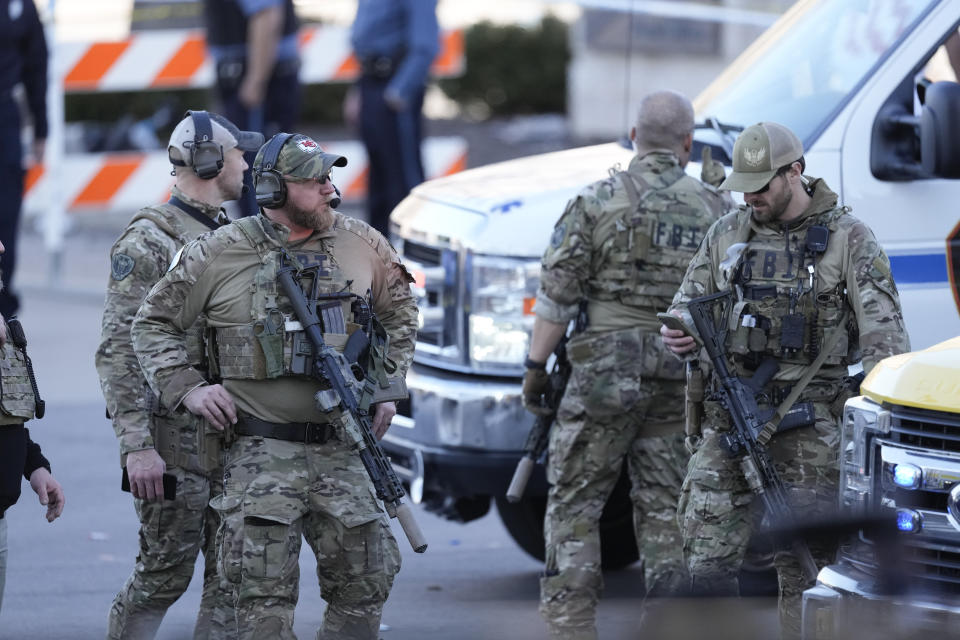 Law enforcement officers look around the scene after an incident following the Kansas City Chiefs victory parade in Kansas City, Mo., Wednesday, Feb. 14, 2024. The Chiefs defeated the San Francisco 49ers Sunday in the NFL Super Bowl 58 football game. (AP Photo/Charlie Riedel)