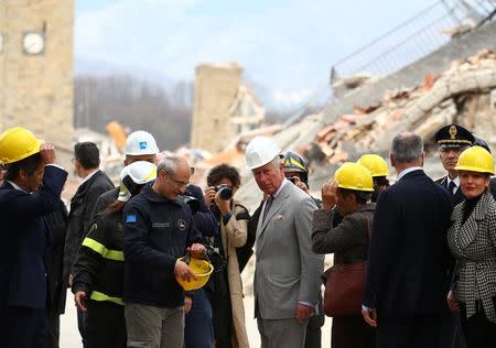 Britain's Prince Charles stands next to an Italy's Civil Protection agency member during his visit to the town of Amatrice, which was levelled after an earthquake last year, in central Italy April 2, 2017. REUTERS/Alessandro Bianchi