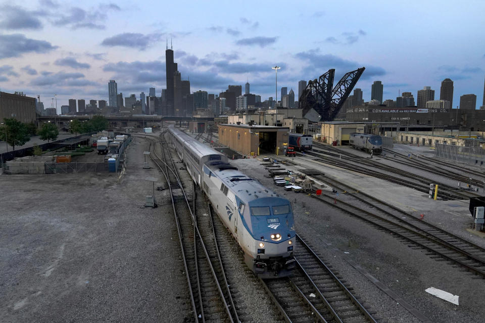 FILE - An Amtrak passenger train departs Chicago in the early evening headed south on Sept. 14, 2022, in Chicago. American consumers and nearly every industry will be affected if freight trains grind to a halt in December. Roughly half of all commuter rail systems rely at least in part on tracks that are owned by freight railroads, and nearly all of Amtrak’s long-distance trains run over the freight network. (AP Photo/Charles Rex Arbogast, File)