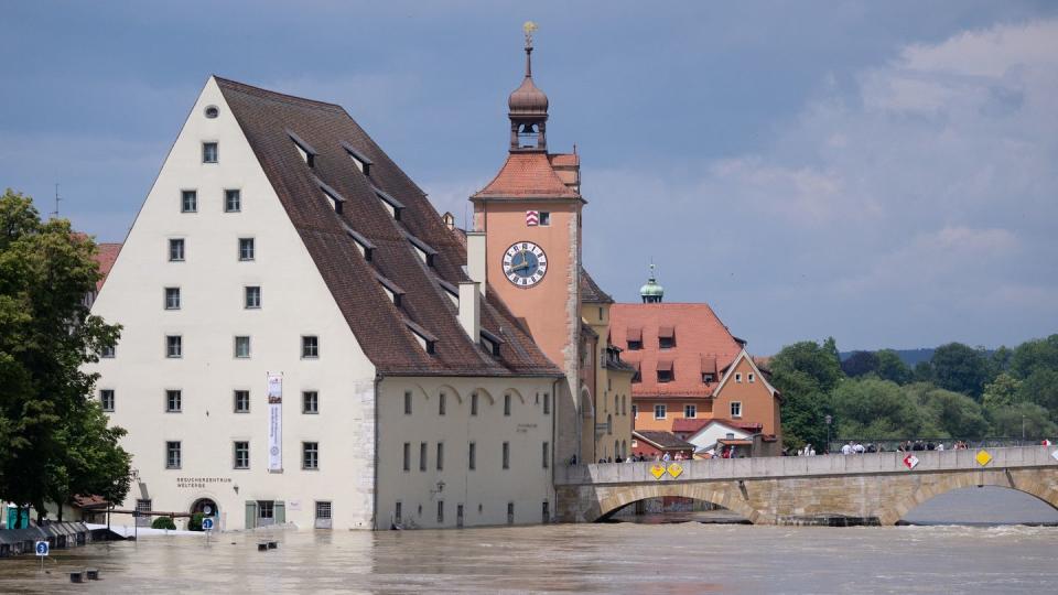 Regensburg: Menschen stehen in der Altstadt auf der Steinernen Brücke und schauen sich das Hochwasser an (Bild: dpa)