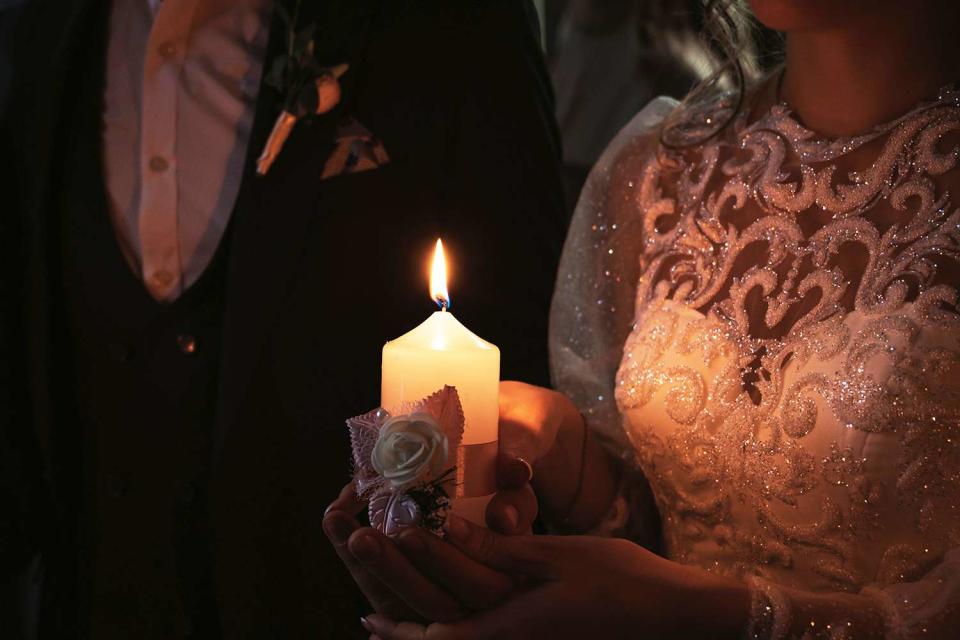 <p>Getty</p> A stock image of a bride and groom with a candle