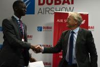 Air Senegal CEO Ibrahima Kane, left, shakes hands with Airbus' chief commercial officer Christian Scherer at a news conference at the Dubai Airshow in Dubai, United Arab Emirates, Tuesday, Nov. 19, 2019. Air Senegal said Tuesday it will purchase eight Airbus A220 aircraft. (AP Photo/Jon Gambrell)